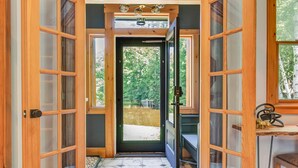 A wooden-framed doorway leading to a garden with a tiled floor.
