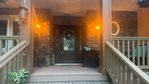 A brick staircase leading to a wooden porch with a stone wall and a door with a glass panel. - Island home on the water with pool.  Bring your boat or jet skis ! Golf near by (Currituck)