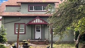A two-story house with a front porch, a small garden, and outdoor furniture. - ♥️ of UofO pristine residence for the World Championships (Eugene)