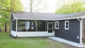 Une maison de plain-pied avec un porche couvert, une porte d’entrée et un petit jardin à l’avant.