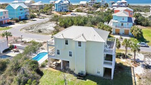 A coastal residential area with houses, a swimming pool, and a beach in the background. - Sea Breeze Manor (Port St. Joe)