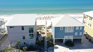 A coastal building with a beach view, a wooden deck, and a small garden. - A Turtle View (Port St. Joe)