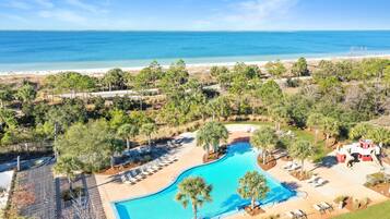 Ein Resort mit Swimmingpool, Zugang zum Strand und Palmen.