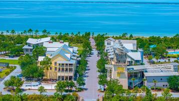 Un resort costero con varias edificaciones, un paseo central y vista al océano.