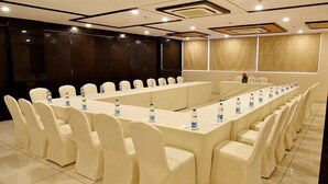 A conference room with a long table and chairs, water bottles on the table, and a dark wall in the background. - Rester Select Jodhpur (Jodhpur)