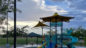 A playground with slides and a covered play area. - Entire home in beautiful  Southwest Las Vegas, NV area! (Las Vegas)