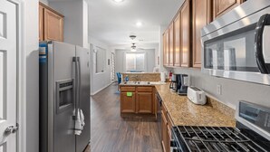 A kitchen with wooden cabinets, stainless steel appliances, and granite countertops. - Entire home in beautiful  Southwest Las Vegas, NV area! (Las Vegas)