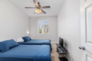 A bedroom with two beds, a ceiling fan, a TV, and a window with blinds. - Entire home in beautiful Southwest Las Vegas, NV area! (Las Vegas)