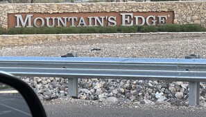 A sign for 'Mountain's Edge' with a stone wall and gravel ground. - Entire home in beautiful Southwest Las Vegas, NV area! (Las Vegas)