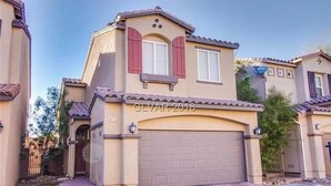 A residential house with a beige facade, red shutters, and a garage door. - Entire home in beautiful  Southwest Las Vegas, NV area! (Las Vegas)