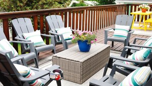 Eine Terrasse mit Gartenmöbeln, darunter Stühle und ein Tisch, sowie einem Blumentopf.