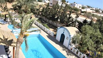 Un resort con piscina, palmeras y vistas de los edificios circundantes.
