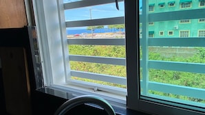 A window with a view of a building and a road. - Fully Equipped Apartment With sea View (Santo Domingo Este)