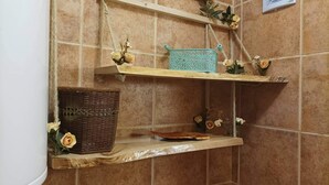 A corner with two shelves, one holding a wicker basket and the other a decorative tray, against a tiled wall. - Near Lake, With View, Center (Ohrid)