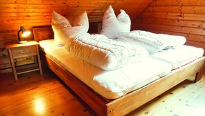 A wooden bed with white bedding in a cabin-style room with a wooden floor and walls. - The House to Stay for Holidays (Oberharz am Brocken)