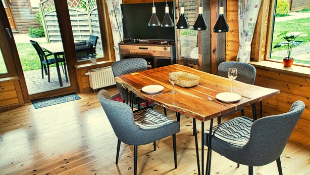 A wooden dining table with four chairs, a basket, and a television in the background. - The House to Stay for Holidays (Oberharz am Brocken)