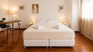 A hotel room with a bed, bedside tables, a desk, and a chair. There are three framed artworks on the wall. - Adelos III Bloom Villa 5BR 360m² - Sauna - Rooftop (Elliniko-Argyroupoli)