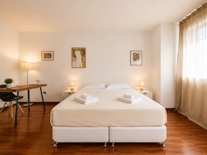 A hotel room with a bed, bedside tables, a desk, and a chair. There are three framed artworks on the wall. - Adelos III Bloom Villa 5BR 360m² - Sauna - Rooftop (Elliniko-Argyroupoli)
