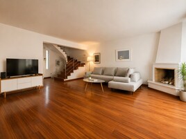 Una sala de estar moderna con un televisor de pantalla plana, un sofá, una mesa de centro y una chimenea.