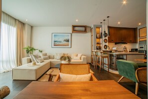 Una sala de estar moderna con sofá, mesa de comedor y área de cocina.