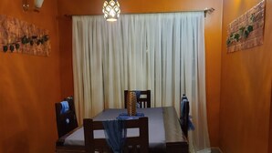 Un comedor con una mesa, sillas y una lámpara colgante.