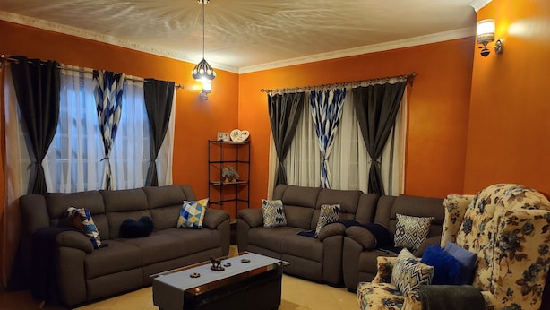 Una sala de estar con dos sofás, una mesa de centro y un sillón estampado.