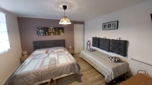 Una camera da letto con due letti, una lampada a sospensione e opere d'arte alle pareti.