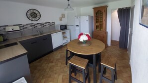 Una cucina compatta con zona pranzo, un forno a microonde, un frigorifero e un armadietto.