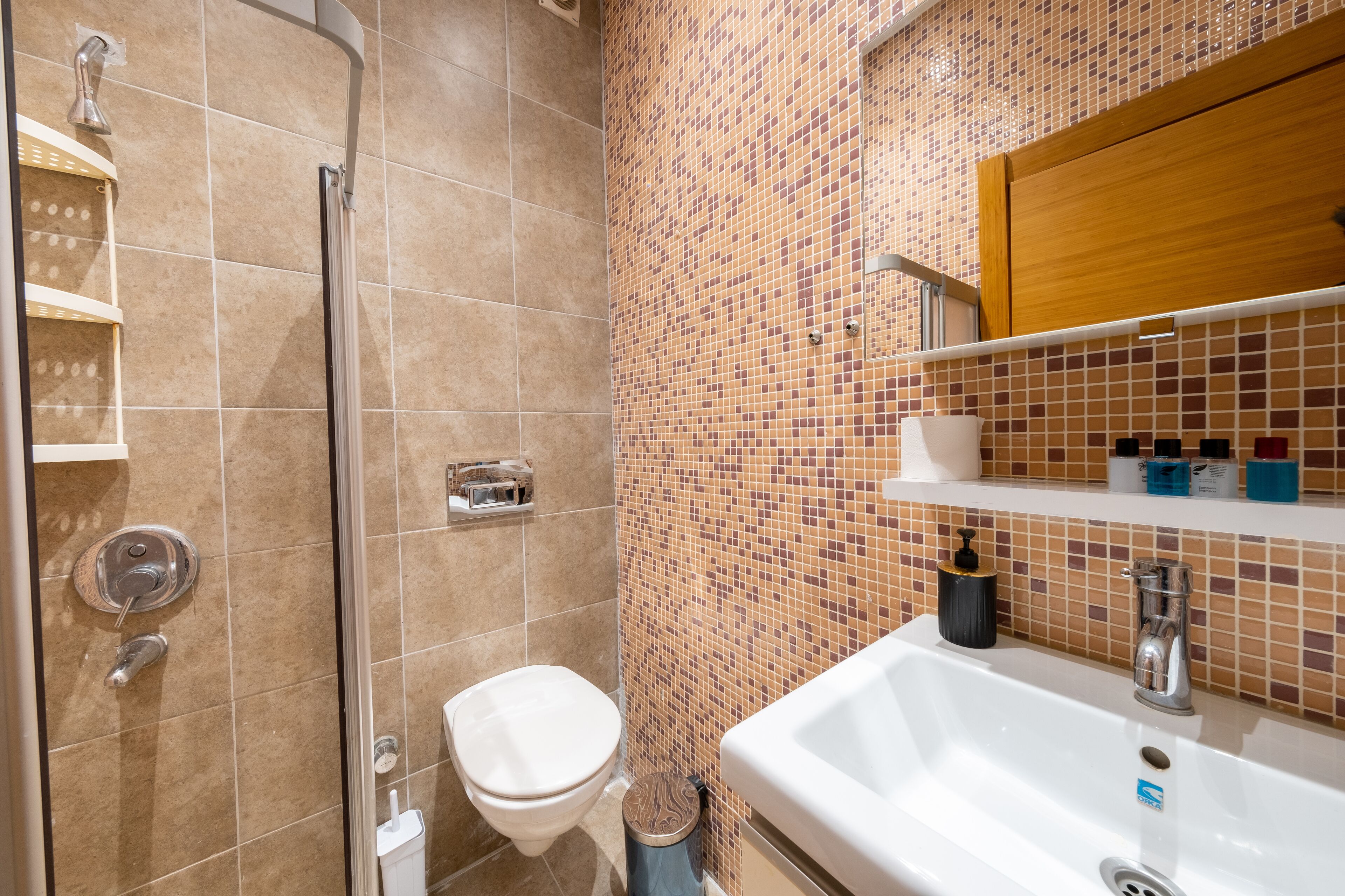 Ein Badezimmer mit Dusche, Toilette und Waschbecken.