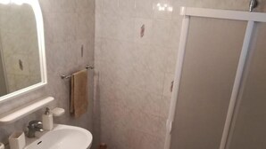 Un baño con lavabo, inodoro y ducha.