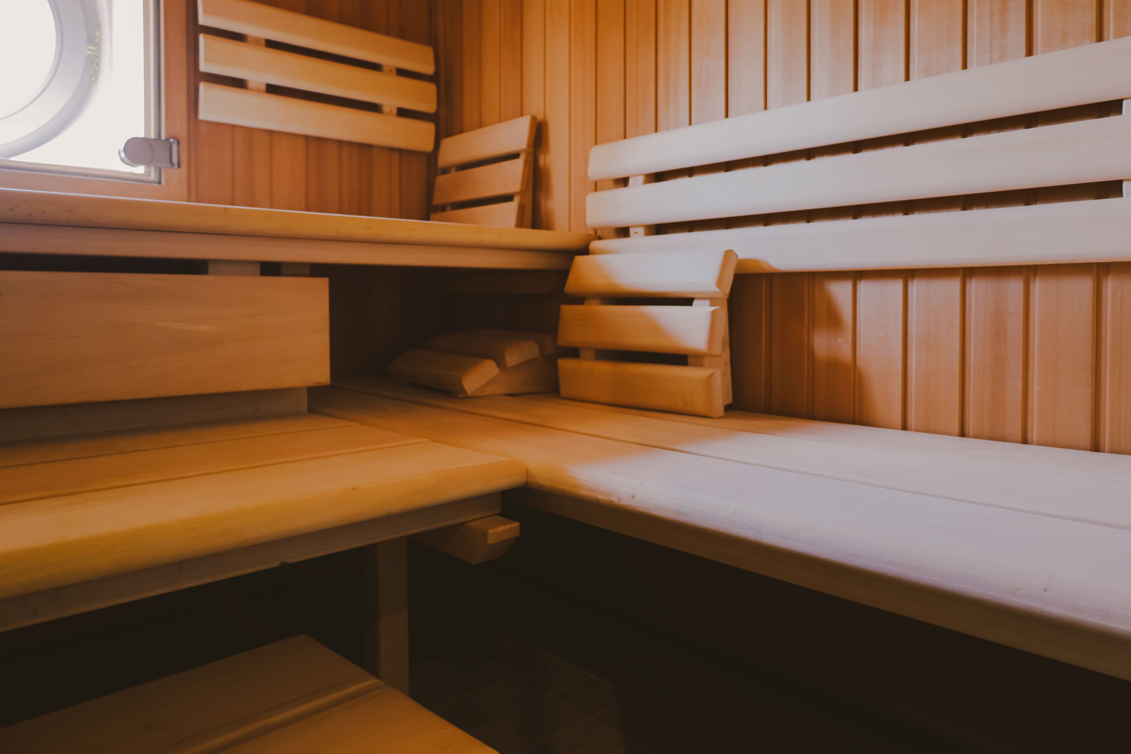 Una sauna con bancos de madera y un banco con una toalla.