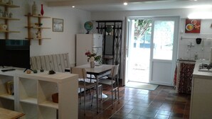 A compact living space with a dining area, kitchenette, and a television. - Appartement au Calme Dans un Parc Ombragé (Montignac)