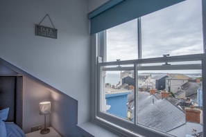 Enjoy a coastal view from the room's large window, featuring a sloped ceiling and skylight.