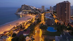 A coastal town with a prominent hill, beachfront, and a large building with a swimming pool. - DRIVE 128 2 Bedrooms Apartment (Benidorm)