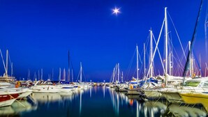 A marina at night with numerous boats docked, calm water, and a bright star in the sky. - DRIVE 128 2 Bedrooms Apartment (Benidorm)