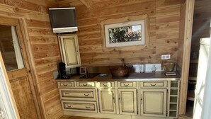 A wooden interior with a kitchen area, including cabinets, a sink, and a window. - Roulotte in the heart of the low gorges of the verdon (Quinson)