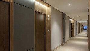 A hotel corridor with wooden doors, numbered 507, and a tiled floor. - Hotel Santika Gunungkidul (Playen)
