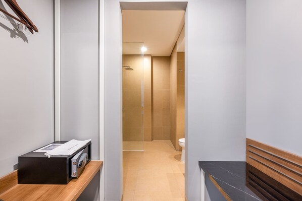 A narrow hallway leading to a bathroom with a shower and toilet. - Hotel Santika Gunungkidul (Playen)