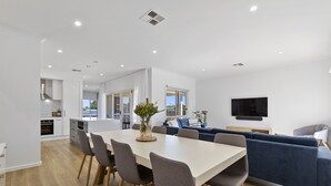 Un soggiorno moderno e open space con angolo ristoro, cucina e zona salotto.
