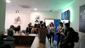 A modern office space with a long table, several chairs, and a few people working. - Ai Hostel (Split)