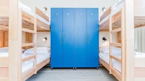 A room with bunk beds and a blue wardrobe with four doors. - Ai Hostel (Split)