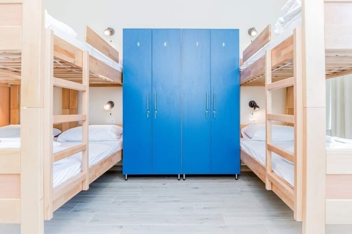 A room with bunk beds and a blue wardrobe with four doors.