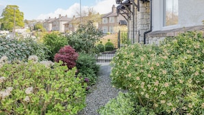 A residential street with houses, a gravel path, and various plants. - Viewpoint (Kendal)