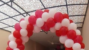 A hallway with a red and white balloon archway. - Hotel Royal Defence (Lahore)