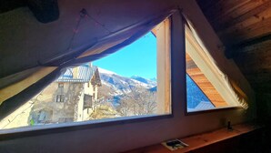 Una habitación con ventana que da a una montaña.