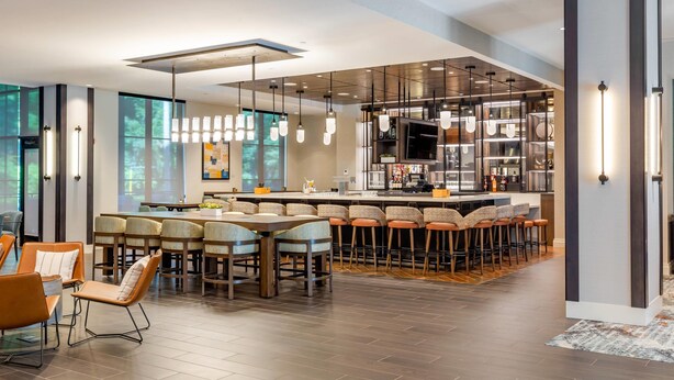 A modern kitchen with a central island, bar seating, and pendant lighting. - Cambria Hotel New Haven University Area (New Haven)