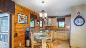 Uma cozinha acolhedora no estilo de cabana, com paredes de madeira, um espaço de refeições e um relógio na parede.