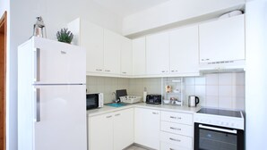 A modern kitchen with white cabinets, a built-in oven, a microwave, and a refrigerator. - Villa With 180 Degree Sea View - Sleeps 2-6 (Malevizi)