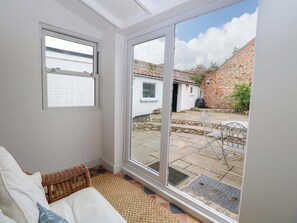 Una habitación con un amplio ventanal corredero que da a un patio exterior.