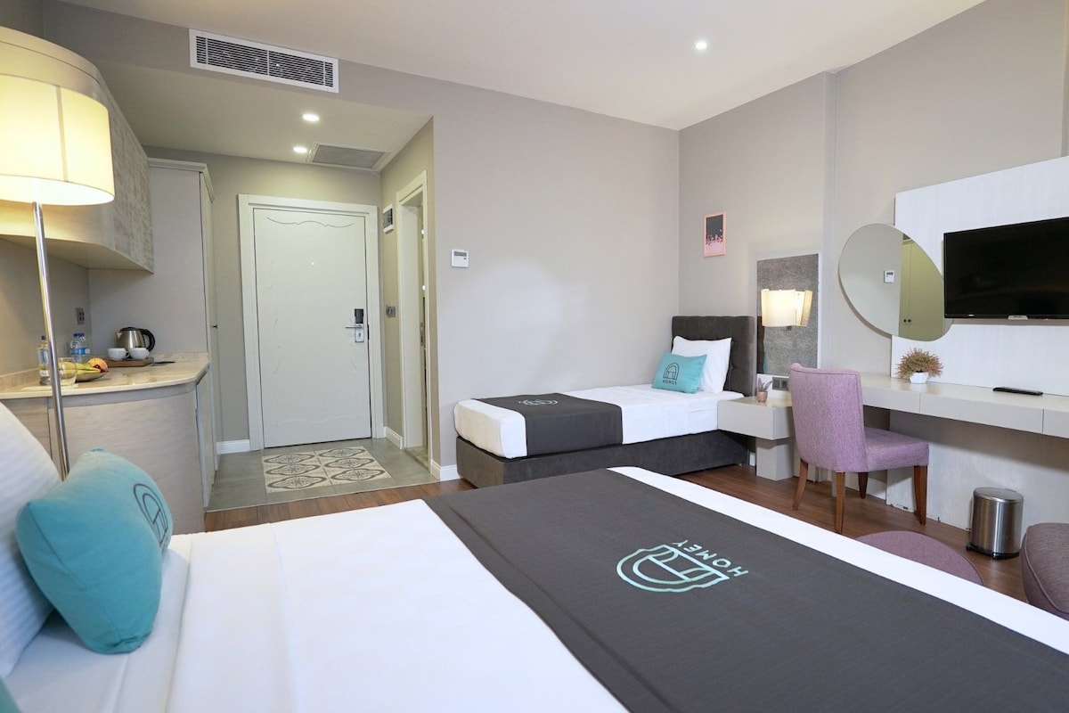 Une chambre d’hôtel comprenant un lit, un bureau, une chaise, une télévision et une salle de bain.